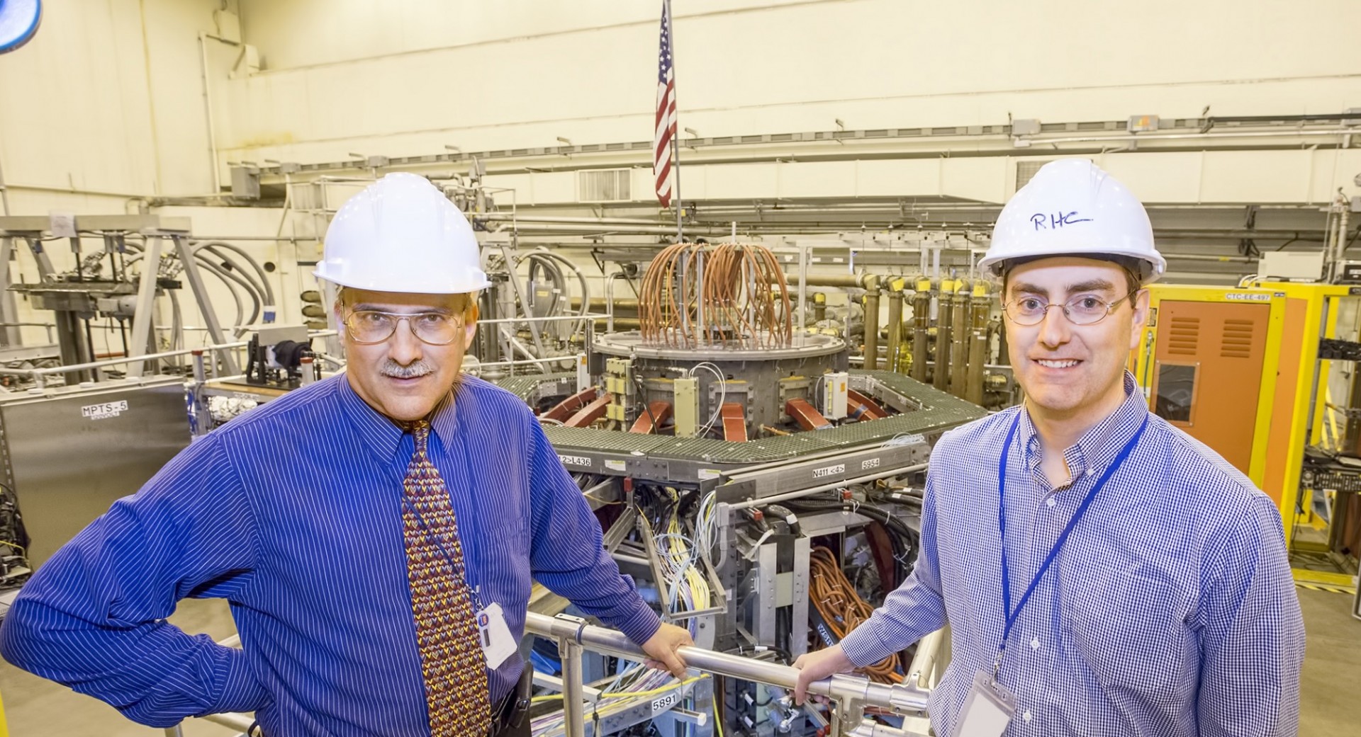 Columbia researchers Sabbagh and Berkery in front of the NSTX-U facility